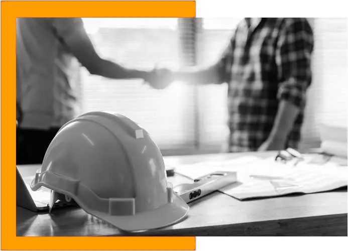 a hard hat and a man shaking hands in front of a desk.